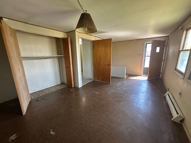 entrance foyer featuring a baseboard radiator and dark floors
