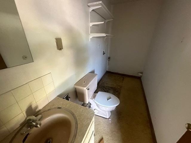 bathroom featuring toilet, backsplash, and vanity