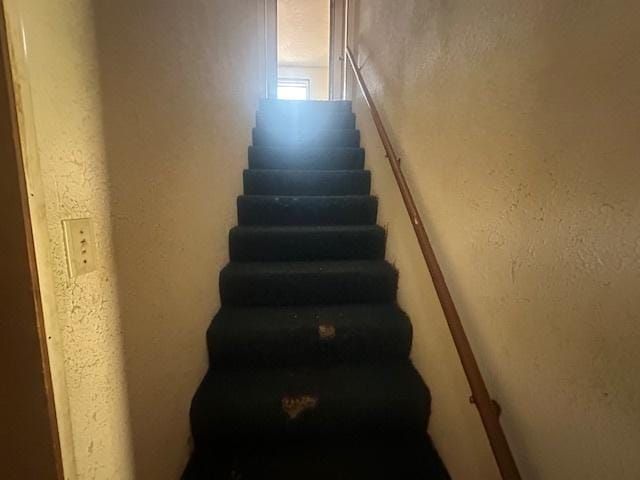 stairs featuring a textured wall
