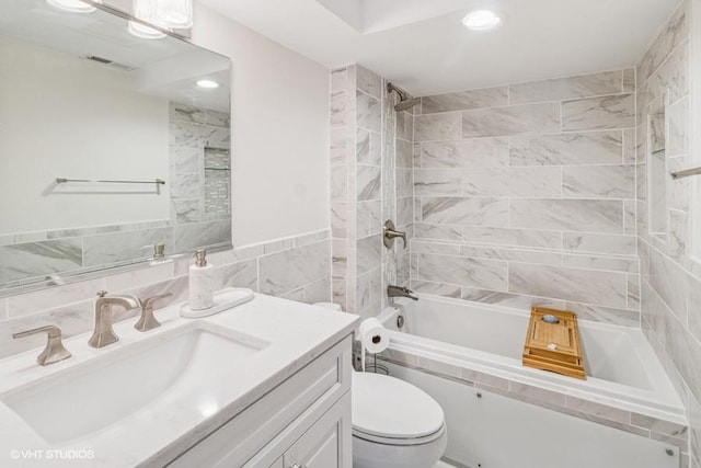 full bath featuring washtub / shower combination, toilet, vanity, recessed lighting, and tile walls