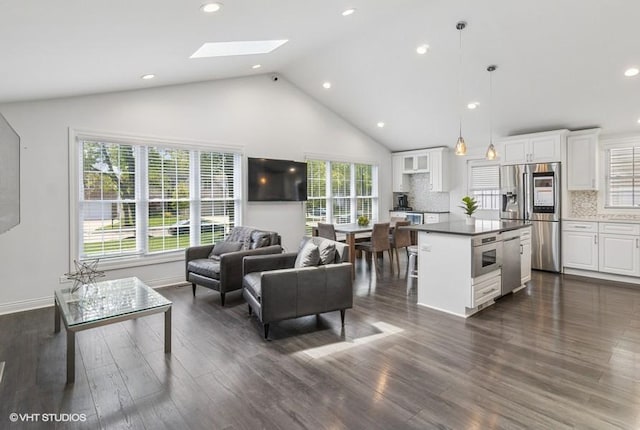 living room with healthy amount of natural light, dark wood-style flooring, high vaulted ceiling, recessed lighting, and a skylight