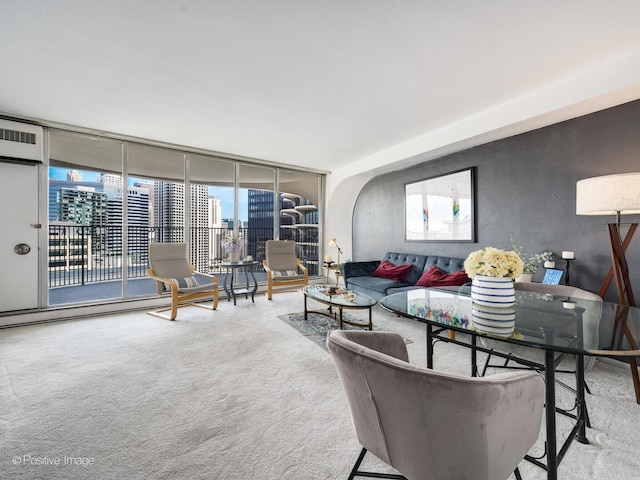 living room with carpet flooring, a wall of windows, and healthy amount of natural light