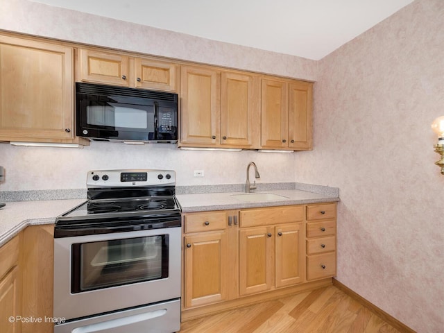 kitchen featuring black microwave, electric range, a sink, light wood-type flooring, and light countertops