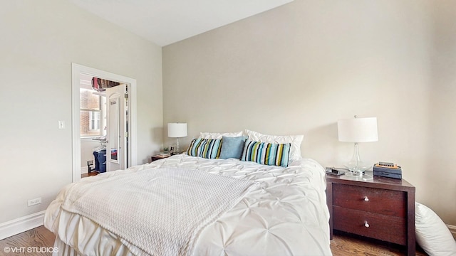 bedroom with baseboards and wood finished floors