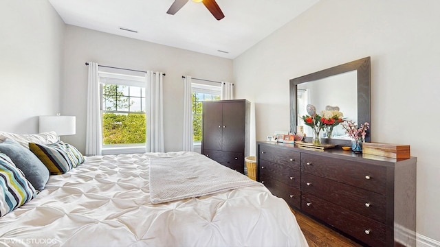 bedroom with vaulted ceiling, a ceiling fan, and dark wood-style flooring