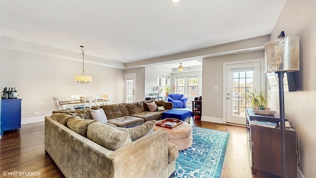 living area featuring baseboards, dark wood-style flooring, and a ceiling fan