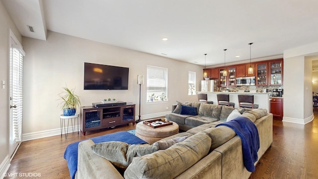 living area with baseboards, dark wood-style floors, recessed lighting, and plenty of natural light