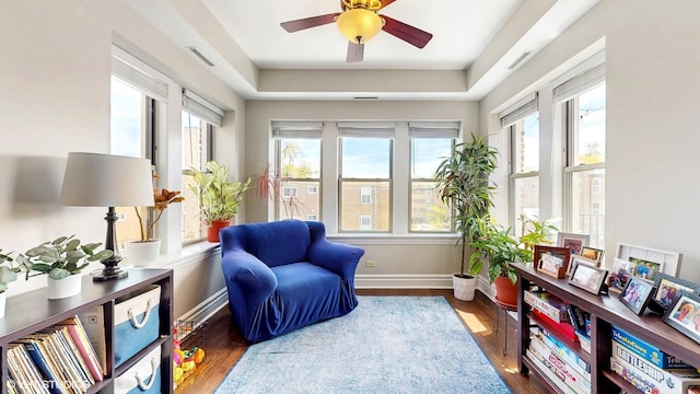 sitting room with wood finished floors, baseboards, and ceiling fan