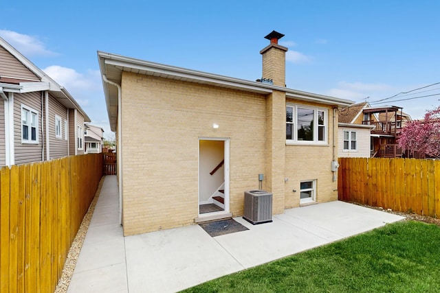 3524 N Natoma Ave, Chicago, IL 60634 - rear view of house with fence, brick siding, a patio area, and a chimney