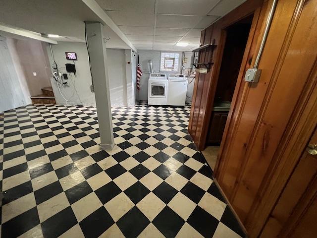 below grade area with independent washer and dryer, light floors, and stairs