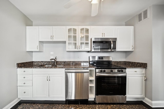 5455 N Sheridan Rd Unit 3804, Chicago, IL 60640 - kitchen with stainless steel appliances, a sink, baseboards, dark stone counters, and white cabinetry