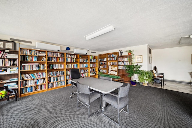 5455 N Sheridan Rd Unit 3804, Chicago, IL 60640 - office featuring bookshelves, a wall unit AC, a textured ceiling, and carpet flooring