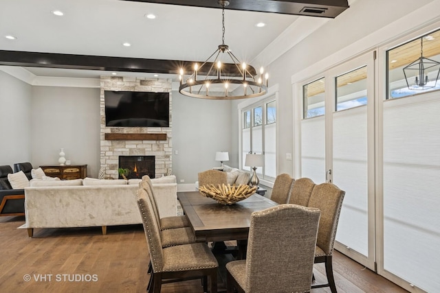 3701 Knollwood Ln, Glenview, IL 60025 - dining room featuring wood finished floors, a chandelier, crown molding, recessed lighting, and a fireplace
