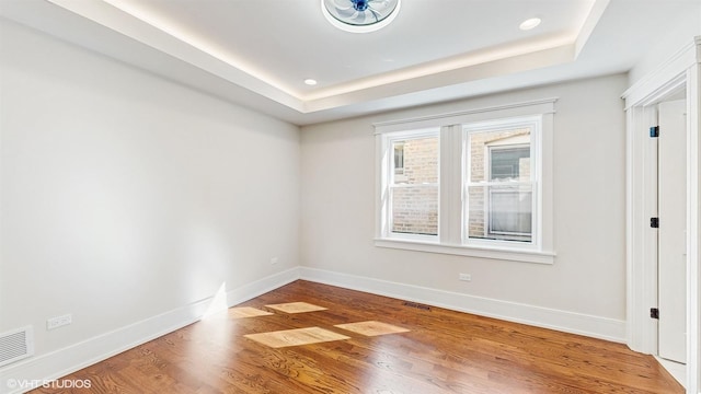 5524 W Byron St, Chicago, IL 60641 - unfurnished room with baseboards, wood finished floors, a raised ceiling, and recessed lighting