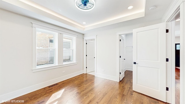 5524 W Byron St, Chicago, IL 60641 - unfurnished bedroom featuring wood finished floors, baseboards, a raised ceiling, a spacious closet, and recessed lighting