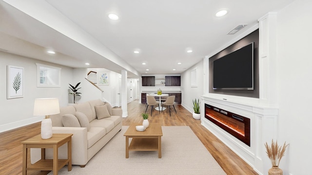 5524 W Byron St, Chicago, IL 60641 - living area featuring baseboards, recessed lighting, stairs, light wood-style floors, and a glass covered fireplace