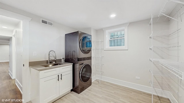 5524 W Byron St, Chicago, IL 60641 - laundry room featuring stacked washer and clothes dryer, cabinet space, baseboards, light wood-type flooring, and recessed lighting