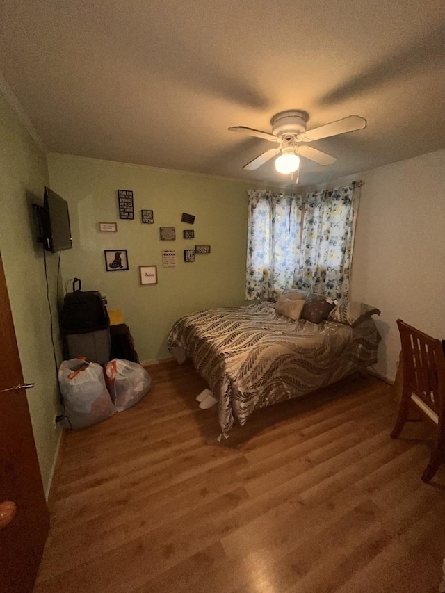 bedroom with light wood-type flooring, ceiling fan, and a textured ceiling