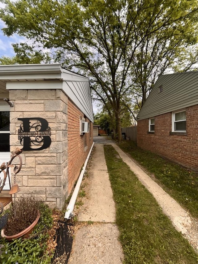 view of side of home featuring brick siding and an AC wall unit