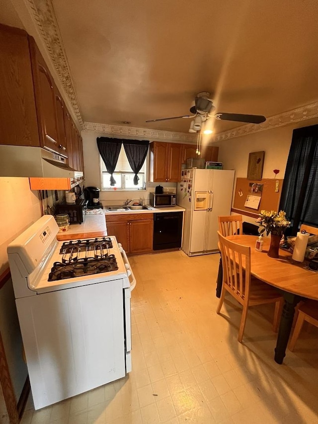 kitchen with white appliances, under cabinet range hood, a sink, a ceiling fan, and light countertops