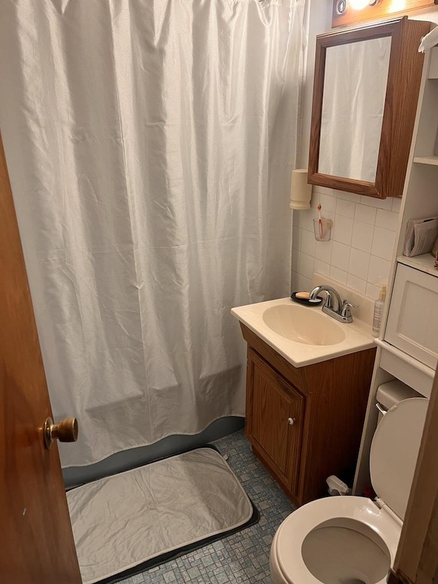 full bath featuring toilet, vanity, backsplash, and tile patterned flooring