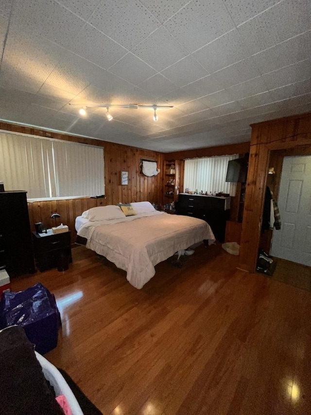 bedroom with wood finished floors and wood walls