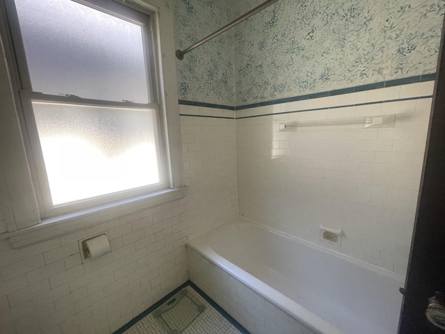 6108 N Maplewood Ave, Chicago, IL 60659 - bathroom featuring wallpapered walls, tile walls, a wainscoted wall, and shower / bath combination