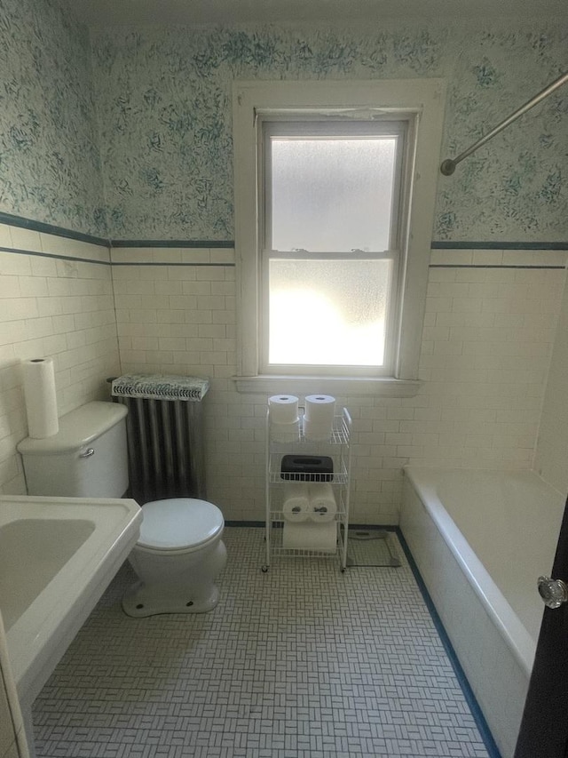 6108 N Maplewood Ave, Chicago, IL 60659 - bathroom with wallpapered walls, toilet, wainscoting, a bathtub, and tile walls