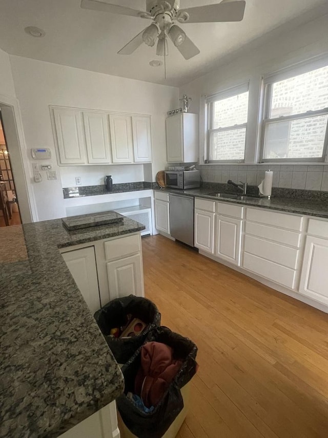 6108 N Maplewood Ave, Chicago, IL 60659 - kitchen with stainless steel appliances, white cabinetry, a sink, light wood-style flooring, and a ceiling fan
