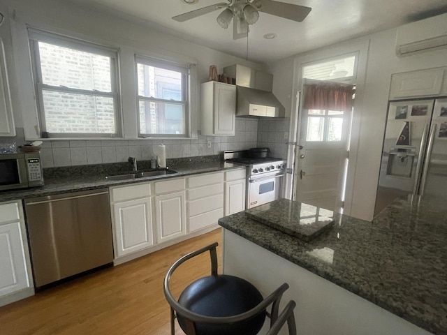 6108 N Maplewood Ave, Chicago, IL 60659 - kitchen featuring appliances with stainless steel finishes, a wall unit AC, wall chimney range hood, a sink, and backsplash