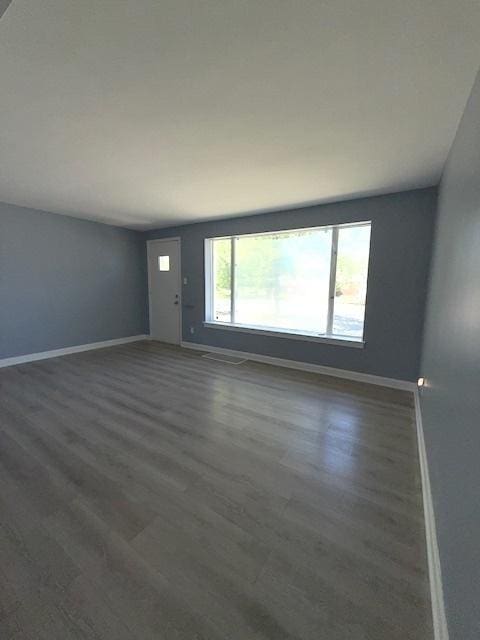 17545 Burnham Ave, Lansing, IL 60438 - unfurnished living room with baseboards and dark wood-type flooring