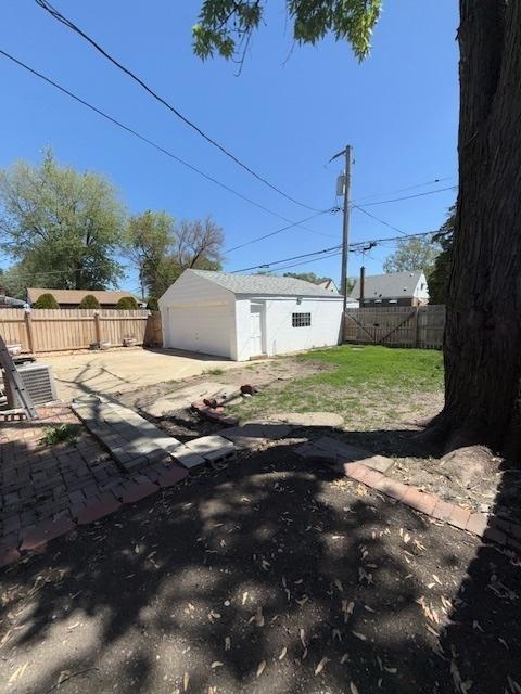 17545 Burnham Ave, Lansing, IL 60438 - fenced backyard featuring a detached garage, an outbuilding, and a patio area
