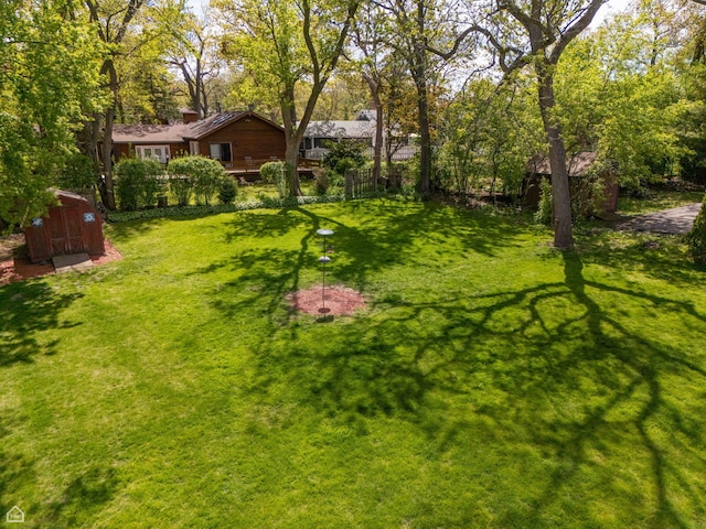 view of green lawn with a shed and an outbuilding