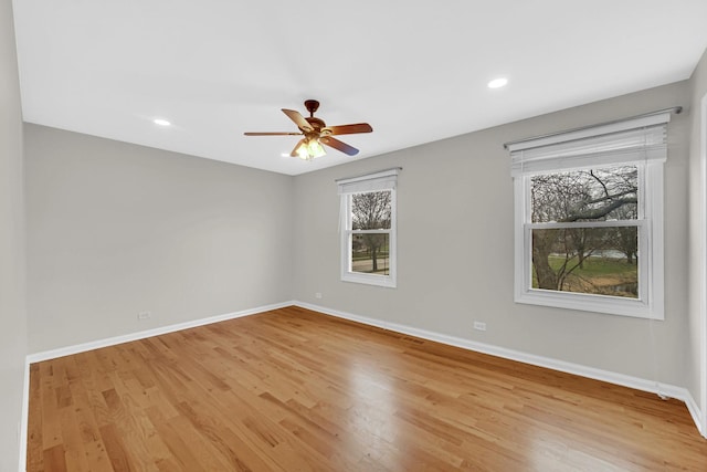 empty room with baseboards, light wood finished floors, a ceiling fan, and recessed lighting