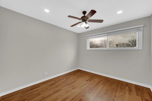 spare room with baseboards, wood finished floors, a ceiling fan, and recessed lighting