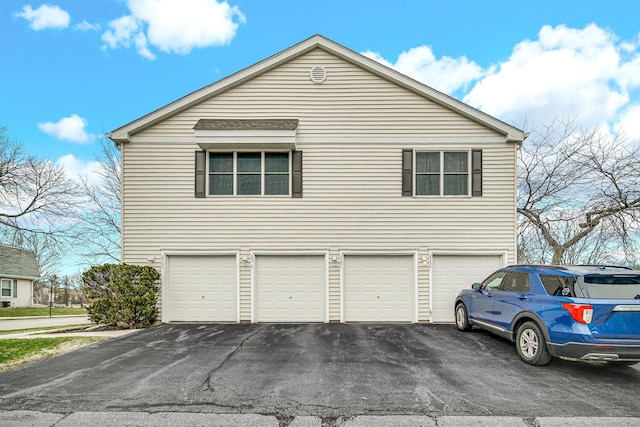 view of home's exterior with a garage and asphalt driveway