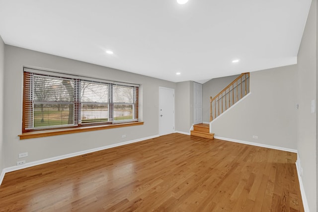 unfurnished living room with stairway, baseboards, wood finished floors, and recessed lighting