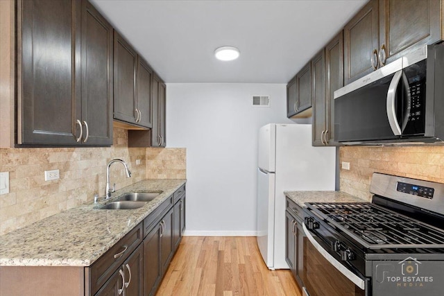 642 Gray Ct Unit 0, Wheeling, IL 60090 - kitchen featuring stainless steel appliances, a sink, baseboards, light wood-type flooring, and dark brown cabinetry