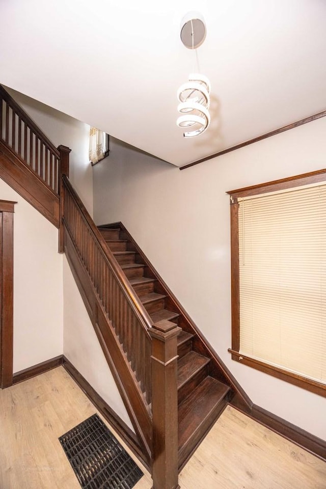 staircase featuring wood finished floors and baseboards