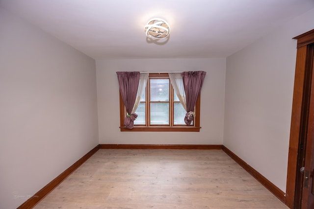 spare room with light wood-style floors and baseboards