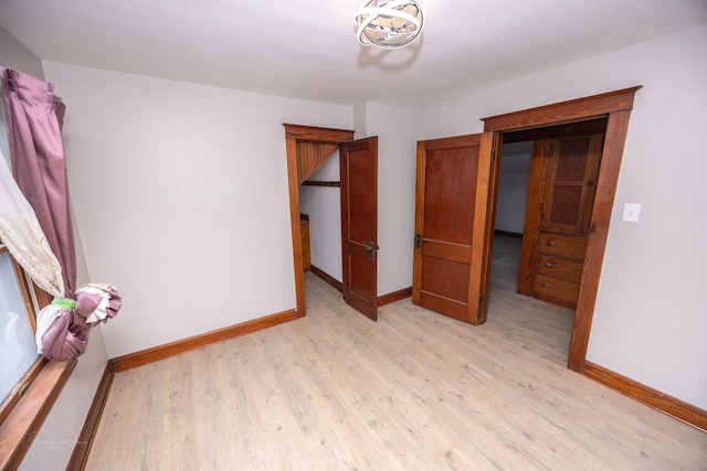 unfurnished bedroom with baseboards and light wood-style flooring