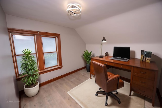 office featuring vaulted ceiling, baseboards, and light wood-style floors