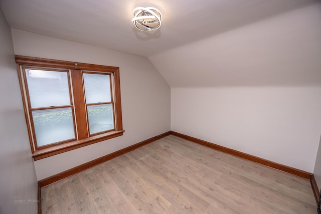 bonus room featuring baseboards, lofted ceiling, and light wood-style flooring