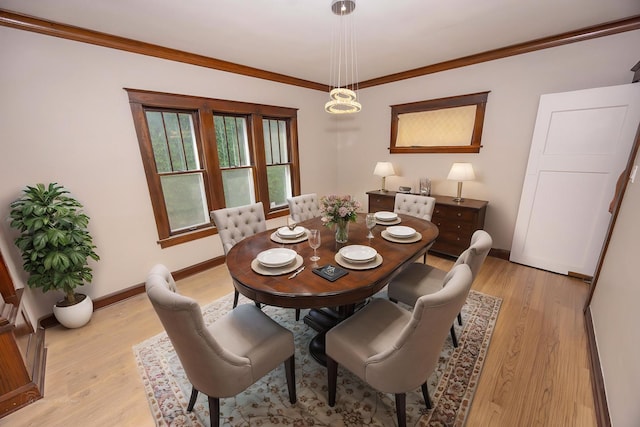 dining room with baseboards, light wood finished floors, and crown molding