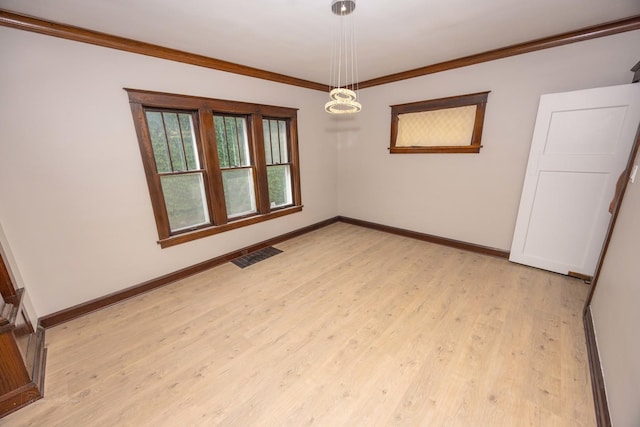 spare room featuring baseboards, light wood-style flooring, and ornamental molding