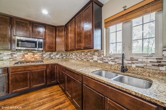 3140 Juniper Ct, Lynwood, IL 60411 - kitchen featuring appliances with stainless steel finishes, a sink, decorative backsplash, dark wood-style floors, and light stone countertops