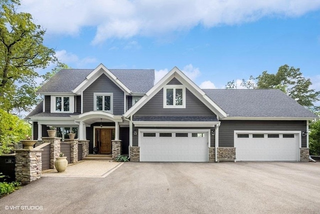 1124 Blackhawk Ave, Mchenry, IL 60051 - craftsman house with asphalt driveway, stone siding, and covered porch