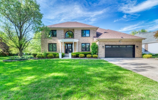 view of front of house featuring a garage, driveway, a front lawn, and brick siding
