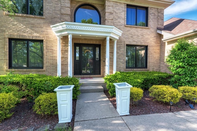 property entrance featuring brick siding
