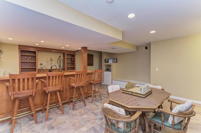 dining space featuring wet bar and recessed lighting